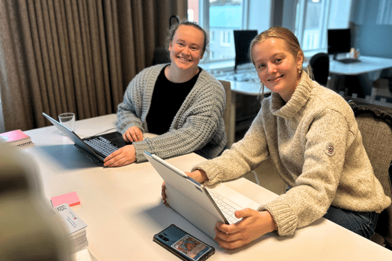 Bilde av praksistudenter, smilende på plassene sine. 